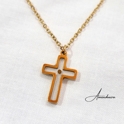 Colar dourado com pendente de cruz sobre fundo branco com texto Amendoeira