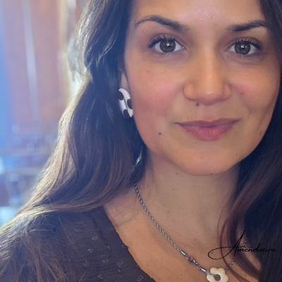 Mulher a usar brincos e colar com pendente em forma de flor branca