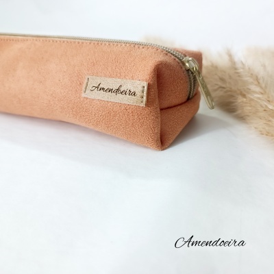Estojo retangular cor de pele com fecho de correr e etiqueta 'Amendoeira'