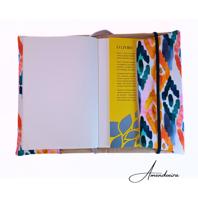 Capa de tecido colorido com caderno aberto e cartão amarelo com texto em português