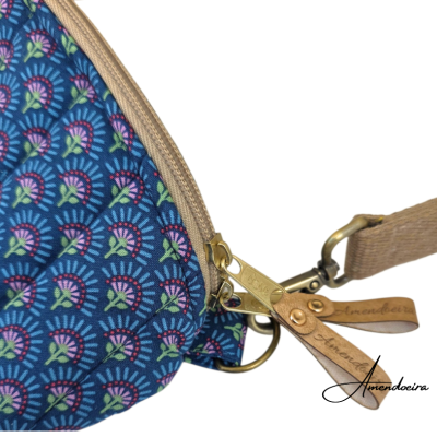 Mala azul com padrão floral e detalhes em bege e dourado