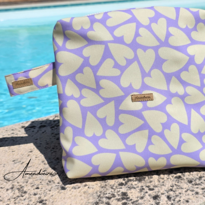 Bolsa lilás com padrão de corações perto de piscina