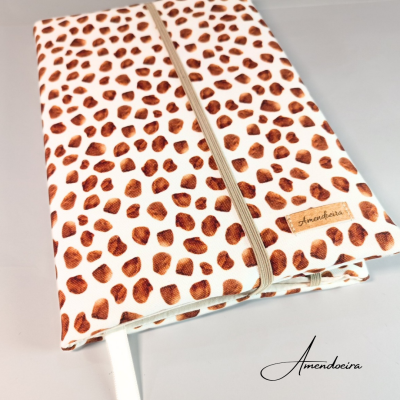 Capa protetora para livro com padrão castanho e branco, elástico e etiqueta Amendoeira