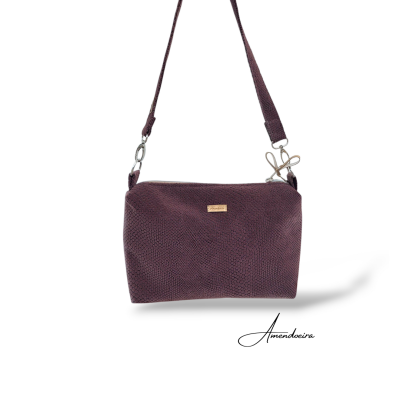 Mala de ombro roxa com padrão texturizado e etiqueta Amendoeira