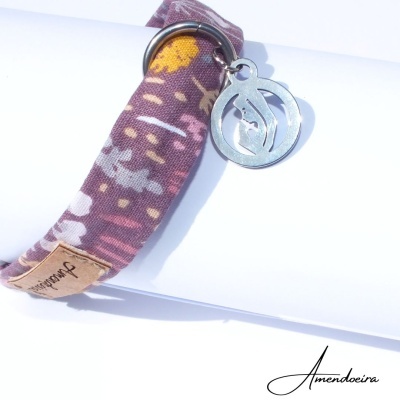 Bracelete de tecido floral roxo com pendente metálico prateado e etiqueta de couro