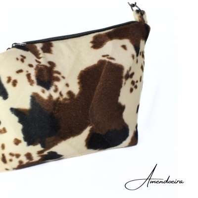 Necessaire com padrão de manchas castanhas e pretas sobre fundo bege