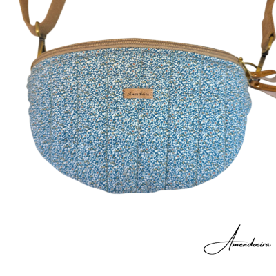 Mala de tiracolo azul com padrão floral e etiqueta Amendoeira