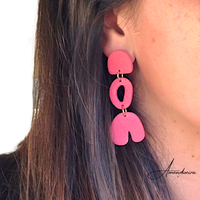 Brincos pendentes rosa com formas geométricas em orelha