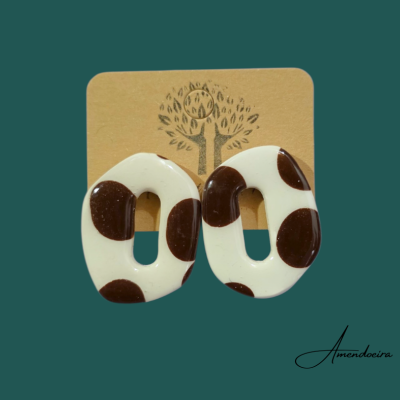 Brincos em resina creme com manchas castanhas em cartão castanho com desenho e assinatura