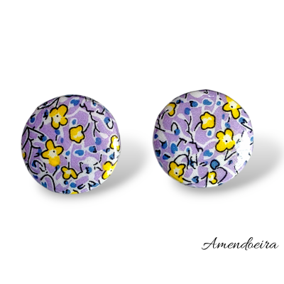 Brincos redondos com padrão floral lilás, amarelo, azul e preto e texto Amendoeira