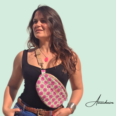 Mulher com bolsa floral tiracolo, vestindo regata preta e jeans azul