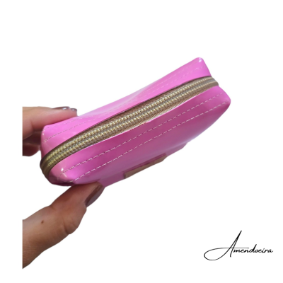 Carteira cor-de-rosa com fecho dourado segurada por mão