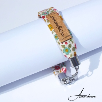 Pulseira em tecido floral com etiqueta 'Amendoeira' e fecho metálico