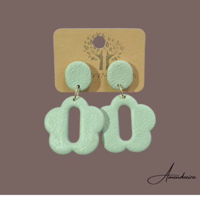 Brincos verdes-água com formato oval e flor em cartão castanho com símbolo de árvore