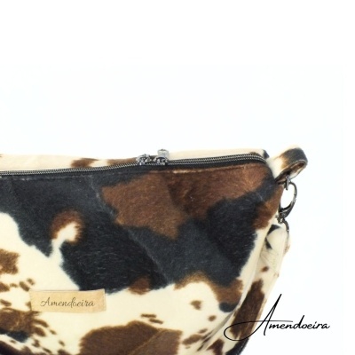 Bolsa pequena com padrão animal em castanho, preto e branco com fecho e etiqueta Amendoeira