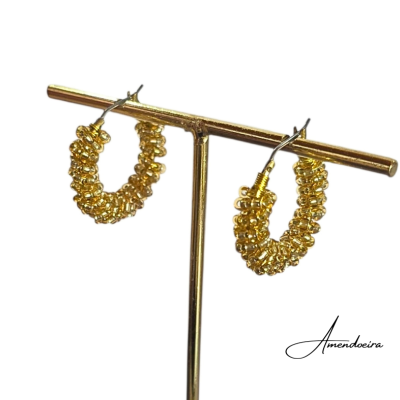 Brincos de argola dourados com pequenas esferas num suporte dourado