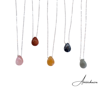 Cinco colares com pedras em forma de gota em várias cores pendurados em correntes prateadas