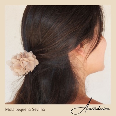 Mola de cabelo pequena bege em formato de flor no cabelo castanho escuro