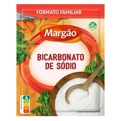 Embalagem de papel de bicarbonato de sódio Margão formato familiar com rótulo vermelho e laranja, utensílio de madeira e vegetais verdes