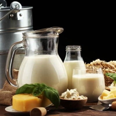 Produtos lácteos vários sobre mesa de madeira com fundo preto