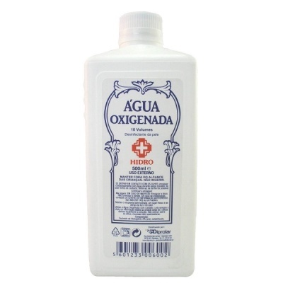 Frasco branco de água oxigenada 500 ml com etiqueta azul e vermelha