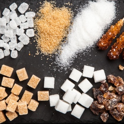 Diferentes tipos e formas de açúcar organizados sobre superfície preta