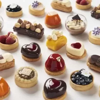 Mini sobremesas variadas coloridas e decoradas numa superfície branca