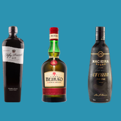 Cinco garrafas de bebidas alcoólicas de várias cores e formatos sobre fundo azul