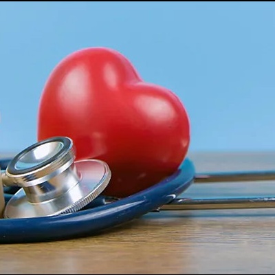 Estetoscópio azul com coração vermelho e figuras de madeira representando família
