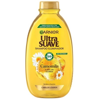 Frasco amarelo de shampoo Garnier Ultra Suave com rótulo de camomila e mel de flores