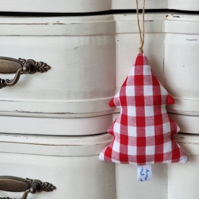 Enfeite de árvore de Natal xadrez vermelho e branco pendurado em móvel branco