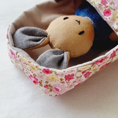 Boneco de coelho em tecido dentro de saco floral.