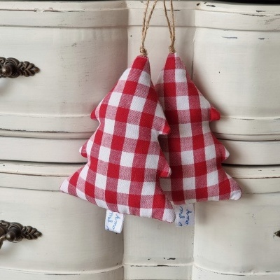 Enfeites de árvore de Natal xadrez vermelho e branco pendurados em móvel de madeira branco antigo