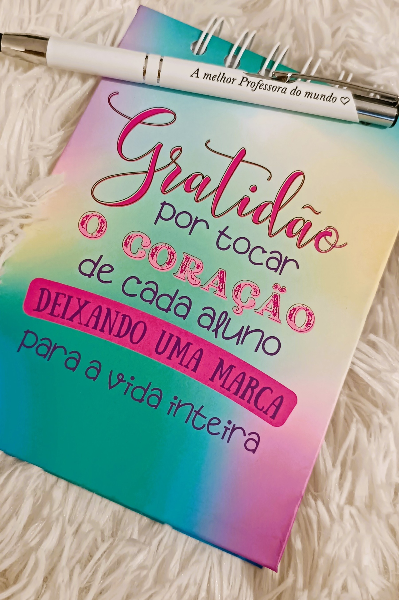 Caderno colorido com mensagem de gratidão e caneta branca com texto para professora