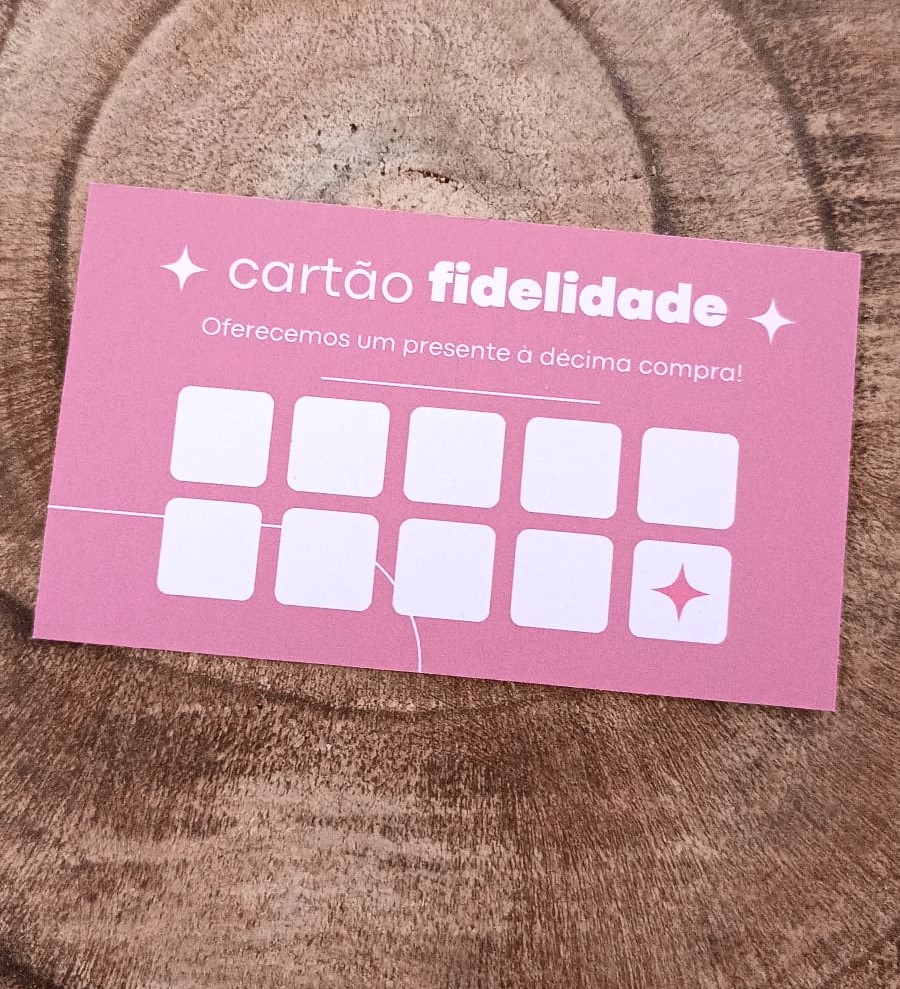 Cartão de fidelidade rosa com texto branco e quadrados para carimbos, usado para promoções.
