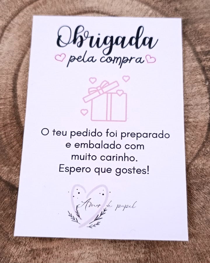 Cartão de agradecimento em português com ilustração de presente e texto de agradecimento sobre fundo de tecido castanho.