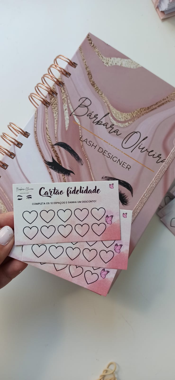 Caderno rosa com texto e cartões fidelidade com corações para marcar