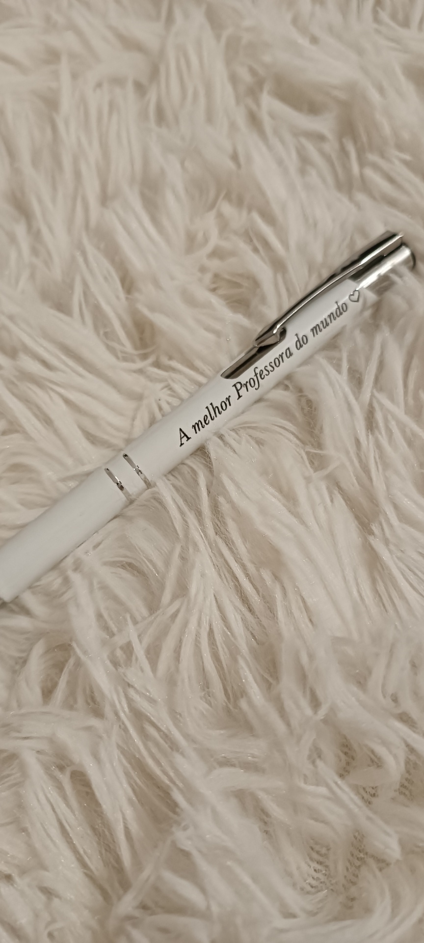 Caneta branca com texto impresso sobre tecido felpudo branco