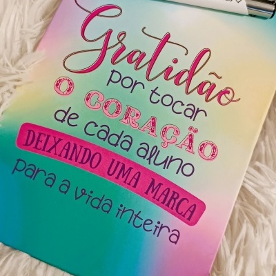 Caderno colorido com mensagem de gratidão e caneta branca com texto para professora
