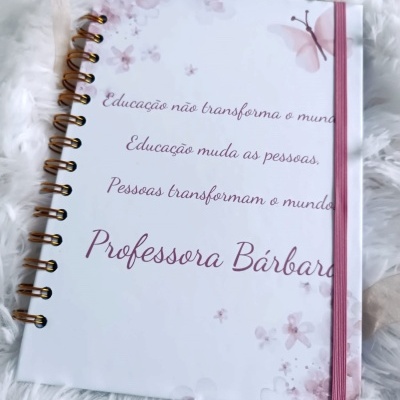 Caderno decorado branco com flores, borboleta e texto em português