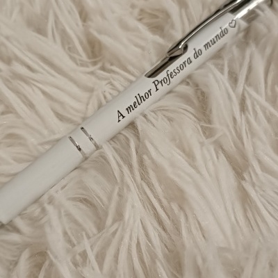 Caneta branca com texto impresso sobre tecido felpudo branco