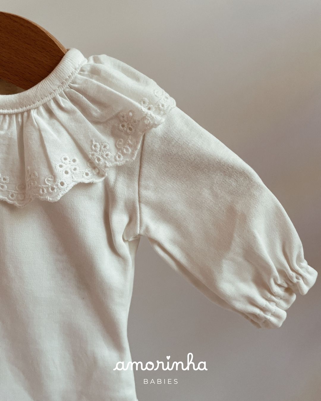 Blusa branca de bebé com gola de babado bordada e mangas compridas