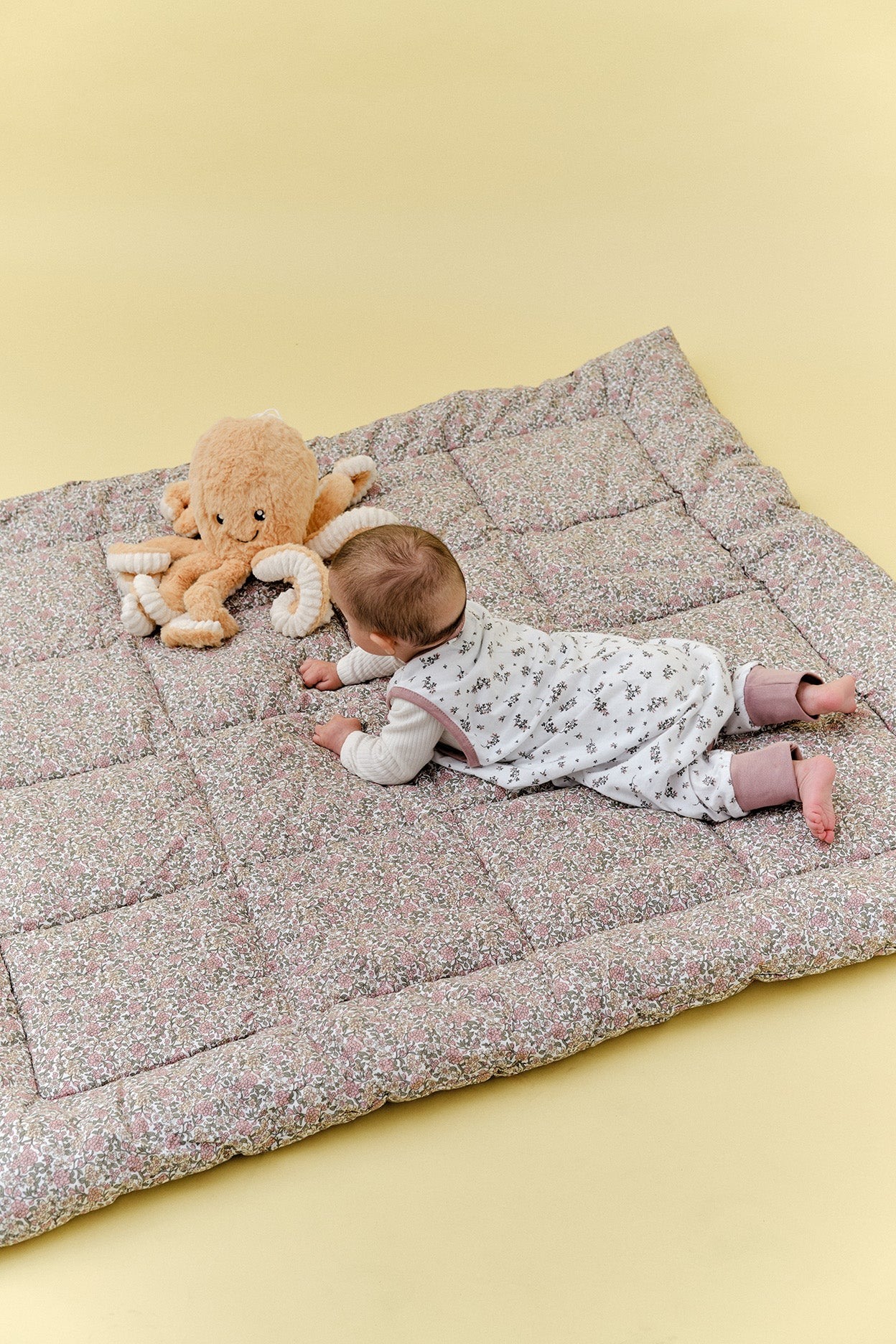 Colchão floral acolchoado com criança e peluche polvo