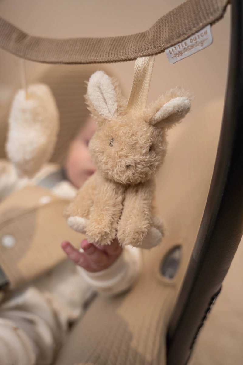 Brinquedo de peluche coelho castanho claro pendurado em suporte bege com etiqueta LITTLE DUTCH