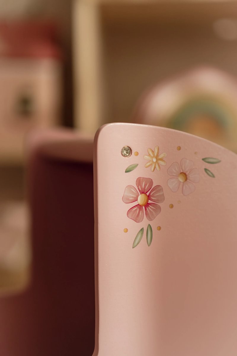 Canto de móvel rosa decorado com flores pintadas e pedra brilhante