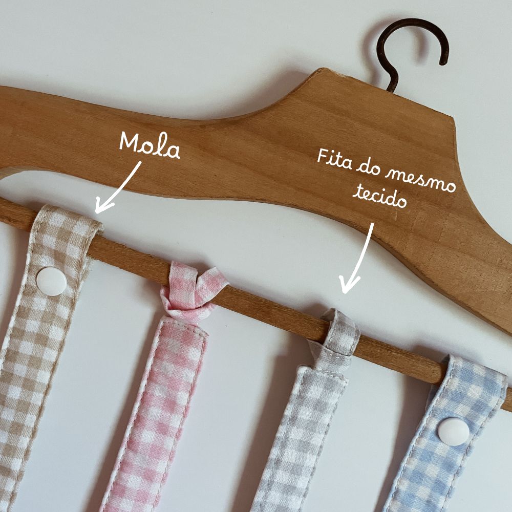 Cabide de madeira com fitas de tecido xadrez em várias cores.