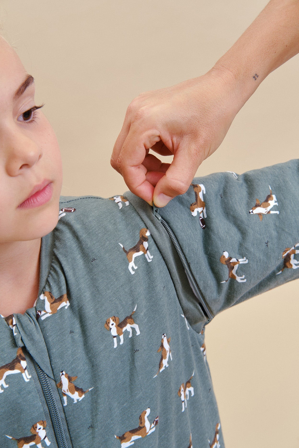 Pijama azul com padrão de cães e fecho de correr usado por criança