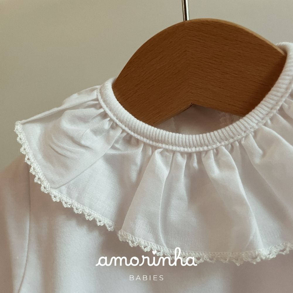 Blusa branca de bebé com gola babado em tecido leve e bordado de renda