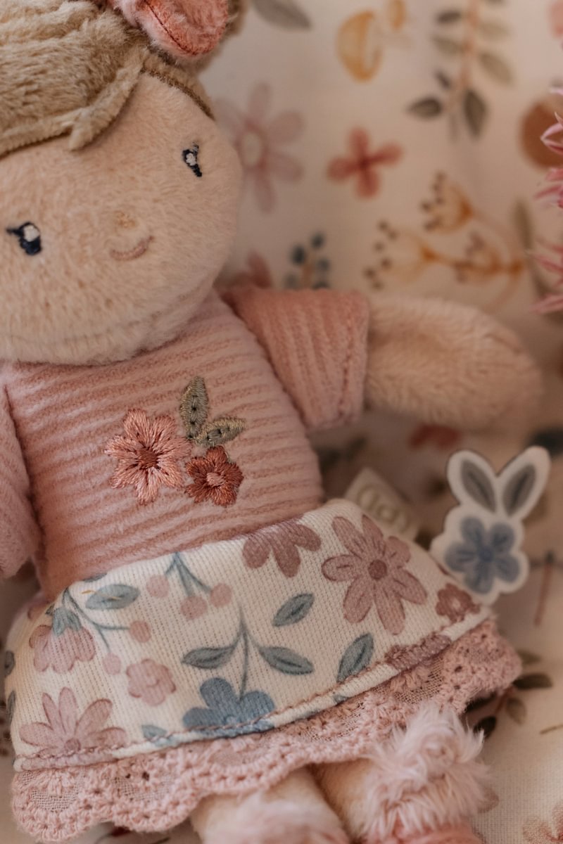Boneca de pelúcia com vestido rosa e padrão floral