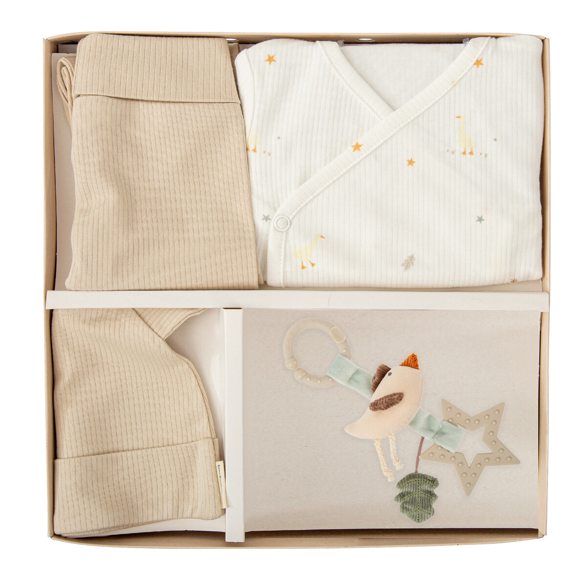 Conjunto de roupa de bebé em caixa com camisola branca estampada, calças e gorro beges, e mordedor em forma de ave.